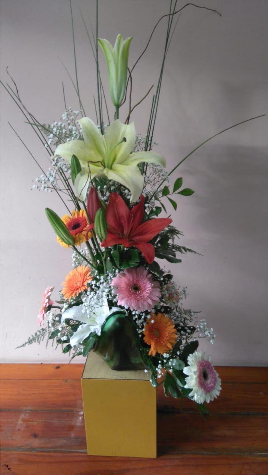 Base de vidrio con liliums y gerberas surtidas